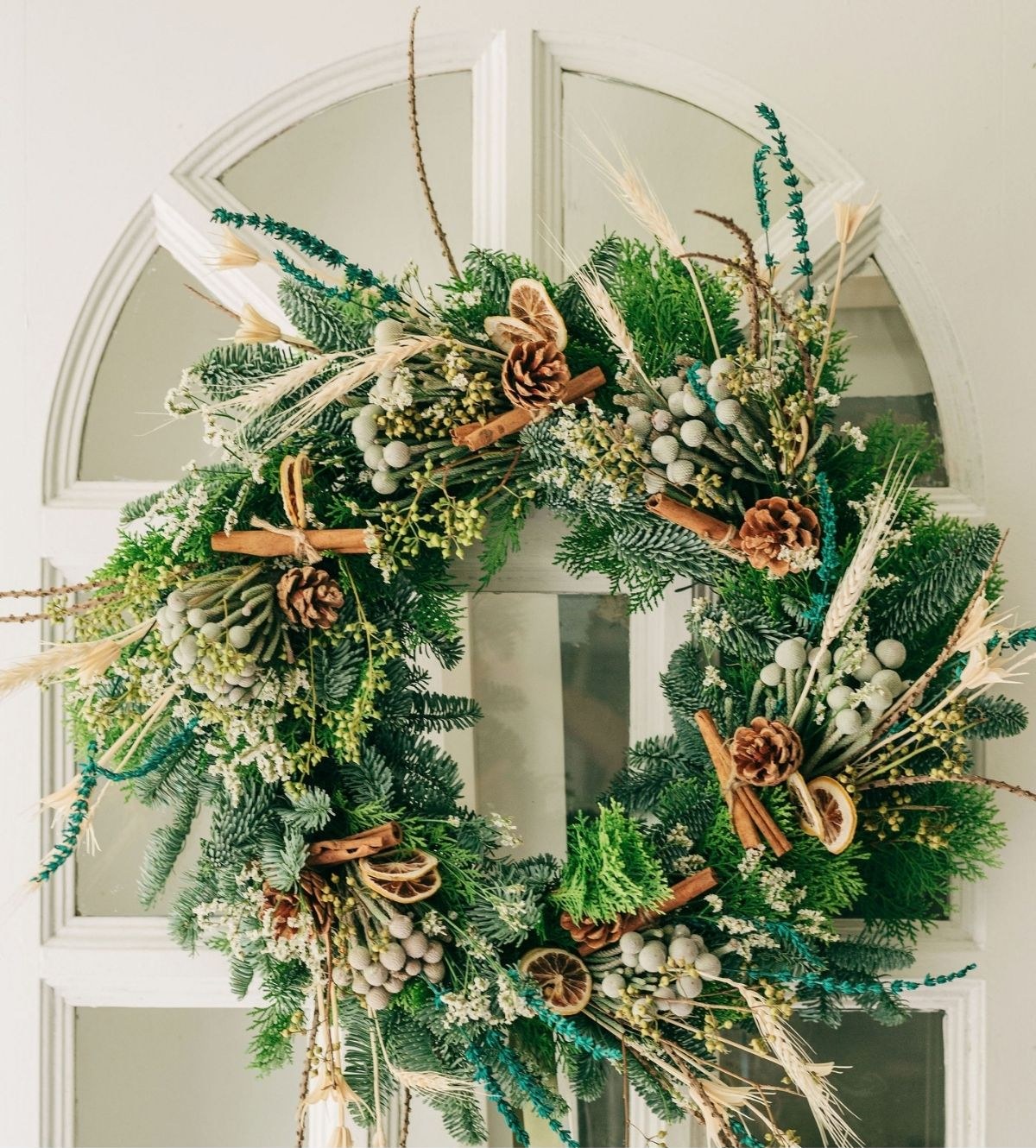 A lush festive wreath by Wildflower Florist with pine, dried florals and cinnamon