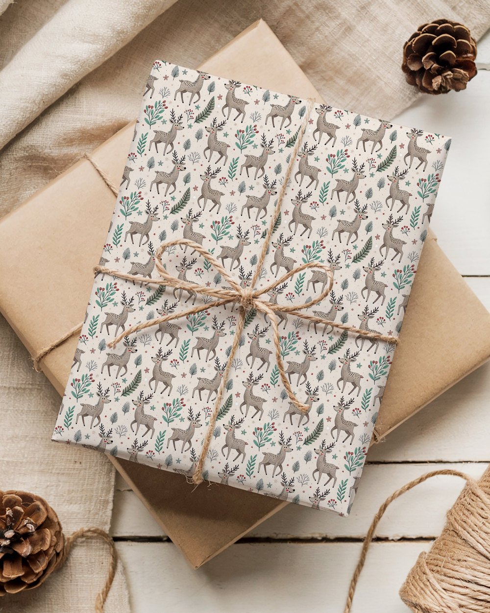 A gift wrapped in reindeer-print recycled paper and tied with natural twine